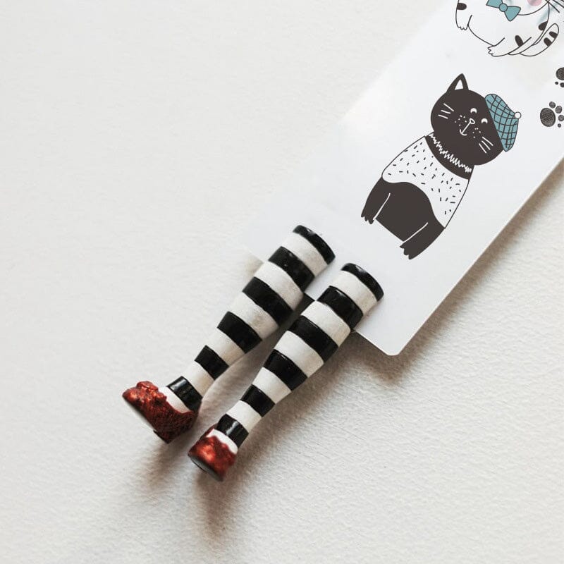 A stack of books with the 3D witch leg bookmark prominently displayed, a quirky reading essential