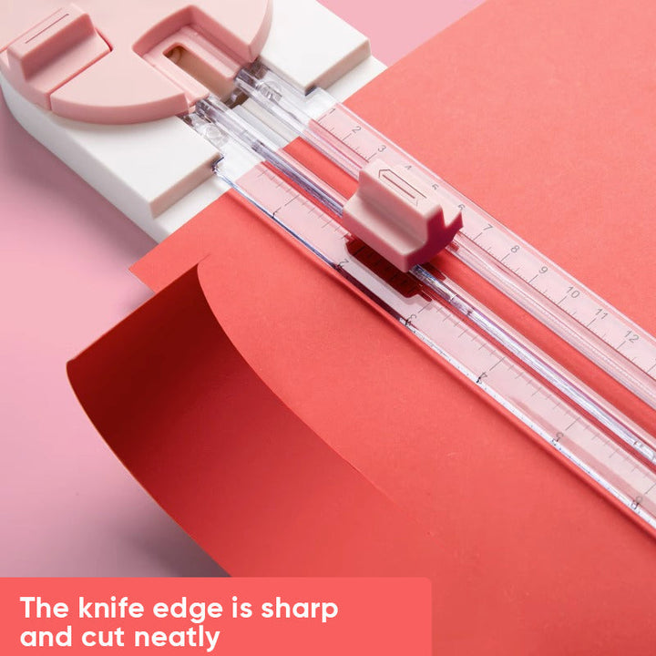 Paper cutter in use, demonstrating straight cut on colorful scrapbook paper sheet