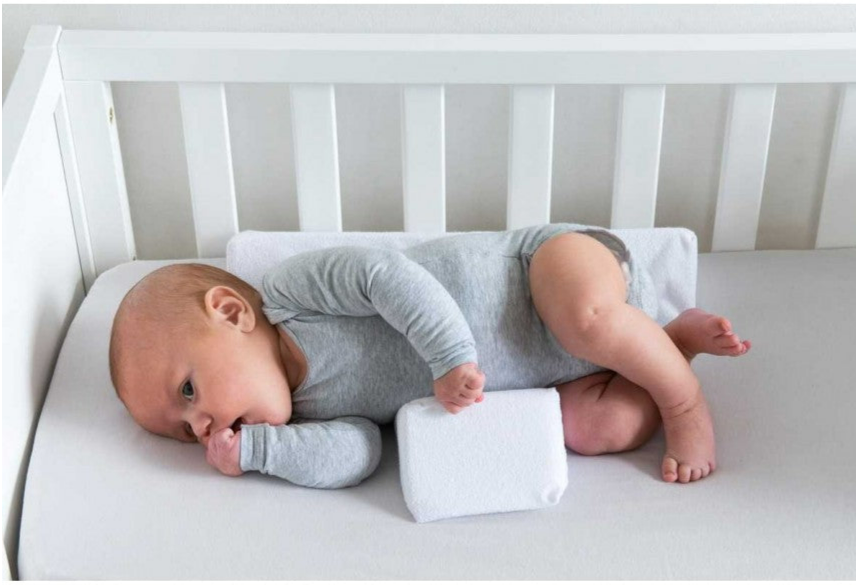 Anti-Roll Adjustable Memory Foam Baby Pillow in Pink, side-sleeper support, gentle and breathable design for newborns.