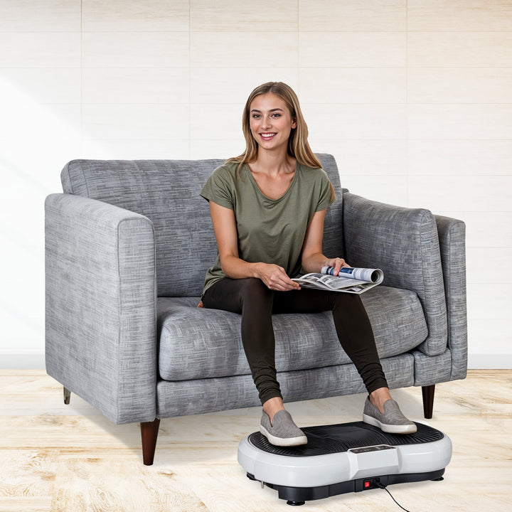 Compact home vibration exercise platform in black with detachable resistance bands, non-slip surface, and remote control.