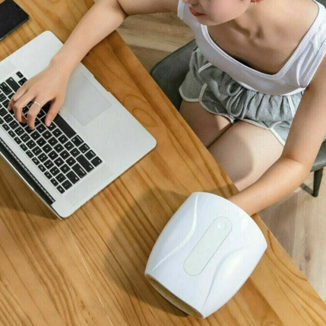 Cordless USB hand massager with white durable exterior, soft cushioning, offering heat and compression for hand relaxation.