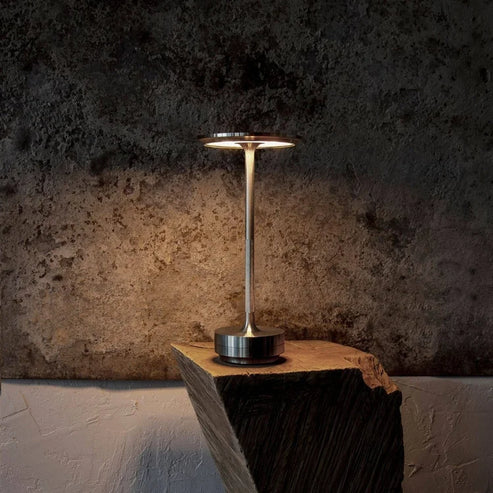 "Elegant wireless table lamp with sleek curves, gold finish; perfect for versatile ambient lighting on any table or desk."