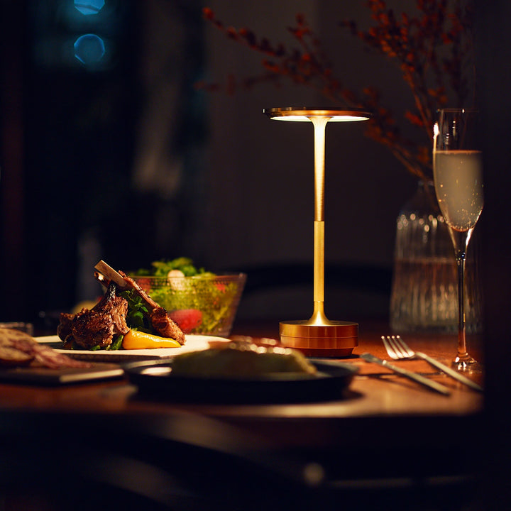 "Elegant wireless table lamp with sleek curves, gold finish; perfect for versatile ambient lighting on any table or desk."
