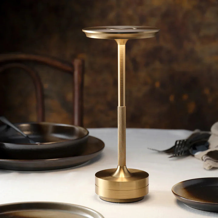 "Elegant wireless table lamp with sleek curves, gold finish; perfect for versatile ambient lighting on any table or desk."