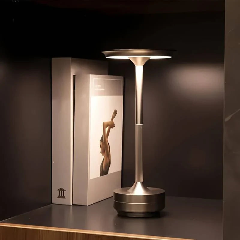 "Elegant wireless table lamp with sleek curves, gold finish; perfect for versatile ambient lighting on any table or desk."