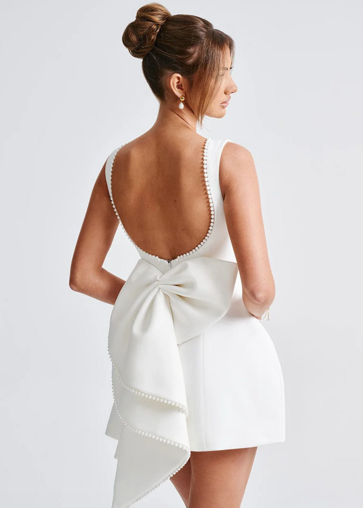Elegant women's mini dress with pearl embellishments, structured fit, in black or white, ideal for evening events and occasio