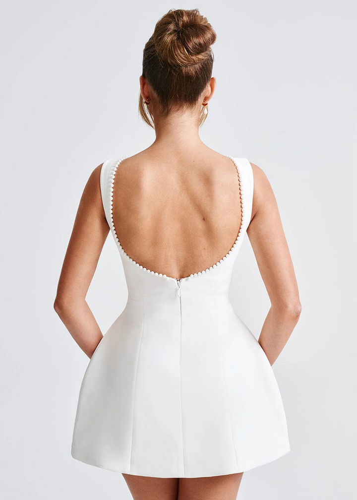 Elegant women's mini dress with pearl embellishments, structured fit, in black or white, ideal for evening events and occasio