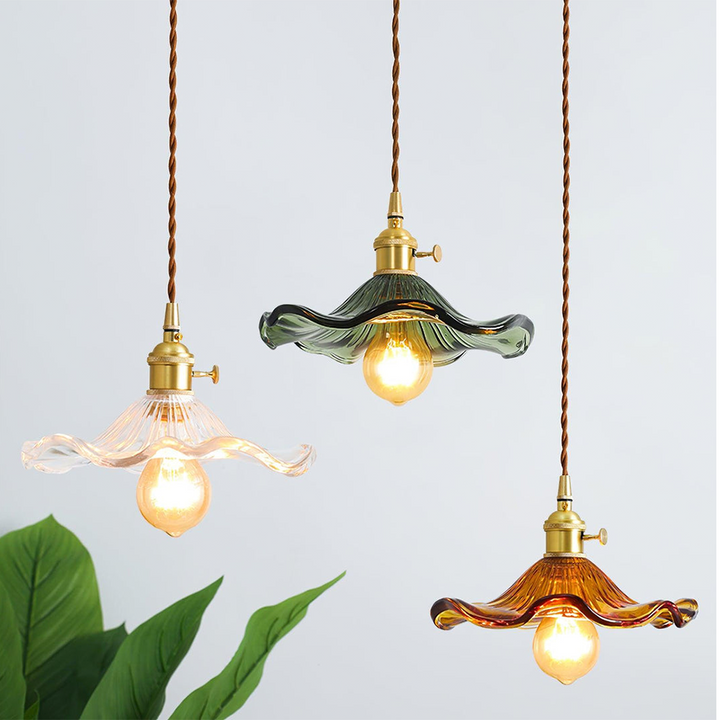 "Hibiscus flower-shaped pendant light in brass and glass, adds elegance and vibrancy to stylish room decor."