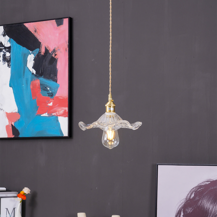 "Hibiscus flower-shaped pendant light in brass and glass, adds elegance and vibrancy to stylish room decor."