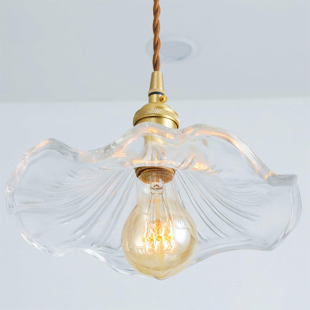 "Hibiscus flower-shaped pendant light in brass and glass, adds elegance and vibrancy to stylish room decor."
