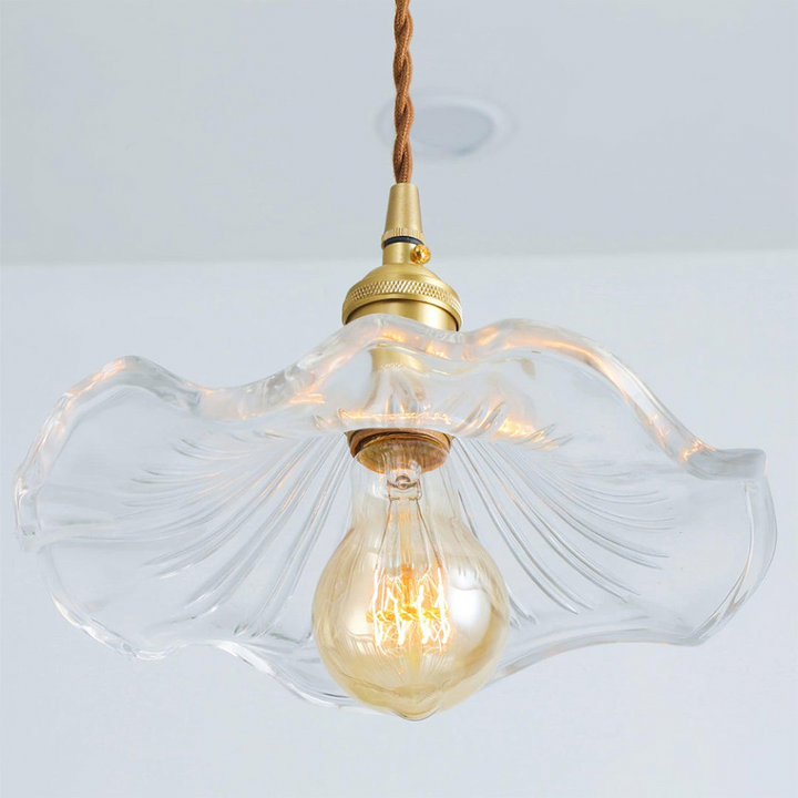 "Hibiscus flower-shaped pendant light in brass and glass, adds elegance and vibrancy to stylish room decor."