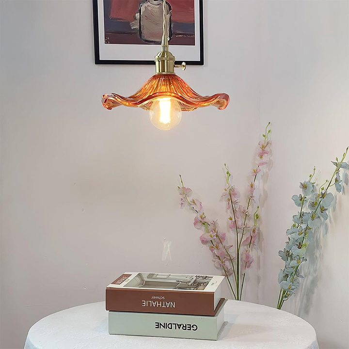 "Hibiscus flower-shaped pendant light in brass and glass, adds elegance and vibrancy to stylish room decor."