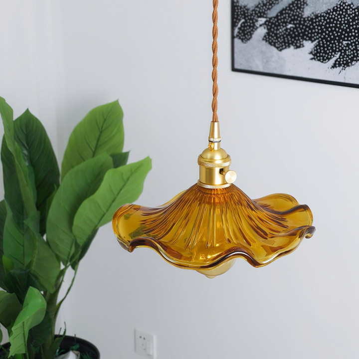 "Hibiscus flower-shaped pendant light in brass and glass, adds elegance and vibrancy to stylish room decor."