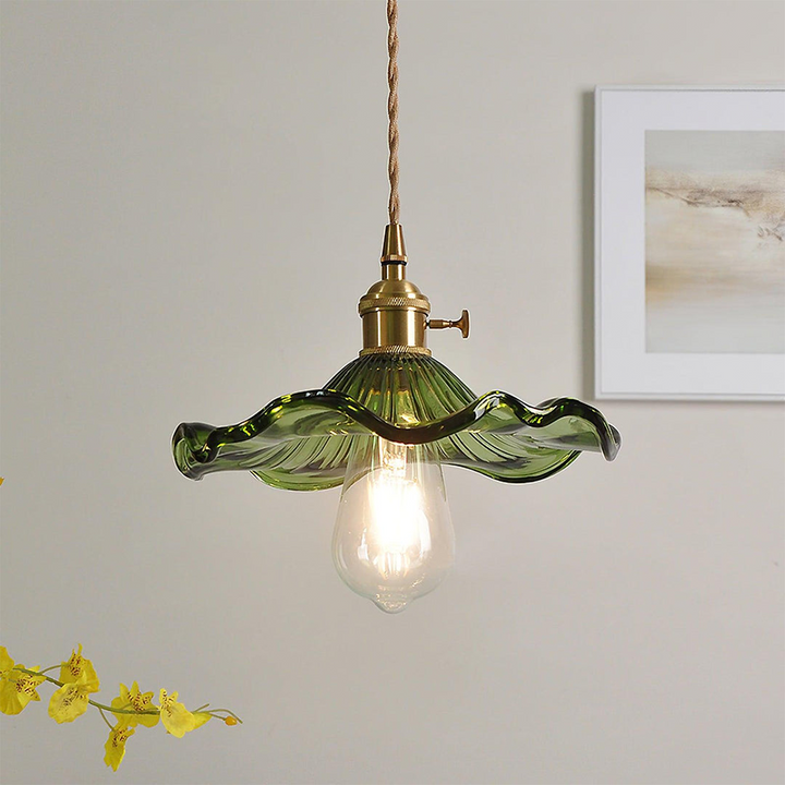 "Hibiscus flower-shaped pendant light in brass and glass, adds elegance and vibrancy to stylish room decor."