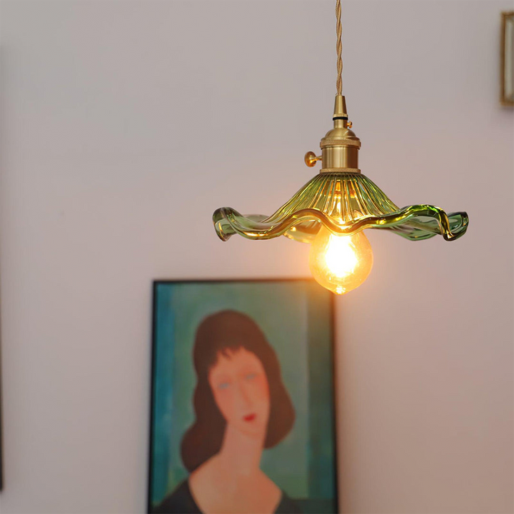 "Hibiscus flower-shaped pendant light in brass and glass, adds elegance and vibrancy to stylish room decor."