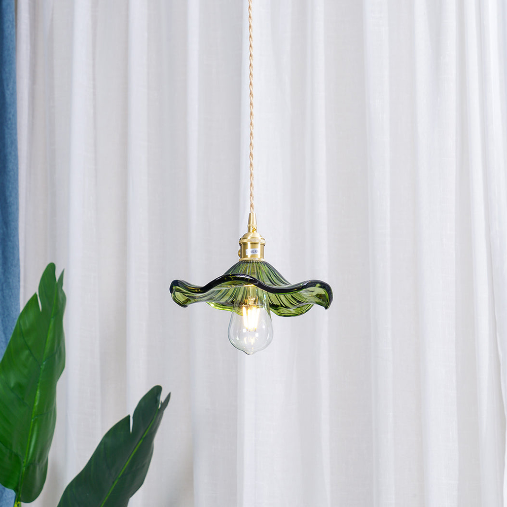 "Hibiscus flower-shaped pendant light in brass and glass, adds elegance and vibrancy to stylish room decor."