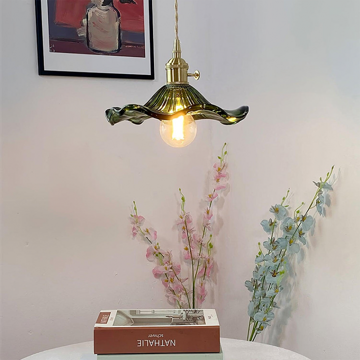 "Hibiscus flower-shaped pendant light in brass and glass, adds elegance and vibrancy to stylish room decor."