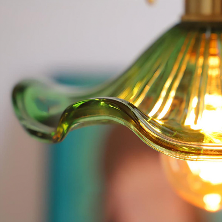 "Hibiscus flower-shaped pendant light in brass and glass, adds elegance and vibrancy to stylish room decor."