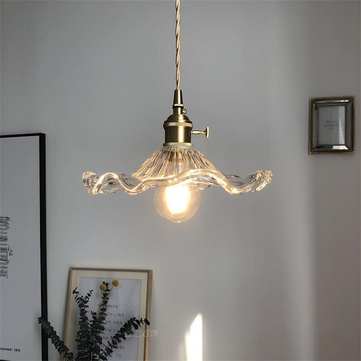 "Hibiscus flower-shaped pendant light in brass and glass, adds elegance and vibrancy to stylish room decor."