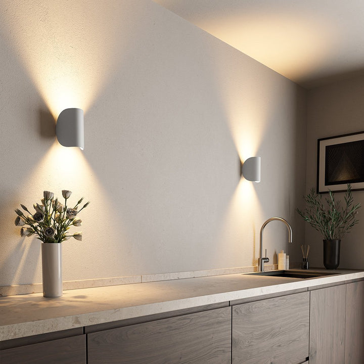 Modern LED up-down wall sconce light in black and white with minimalist design, perfect for indoor ambient lighting.
