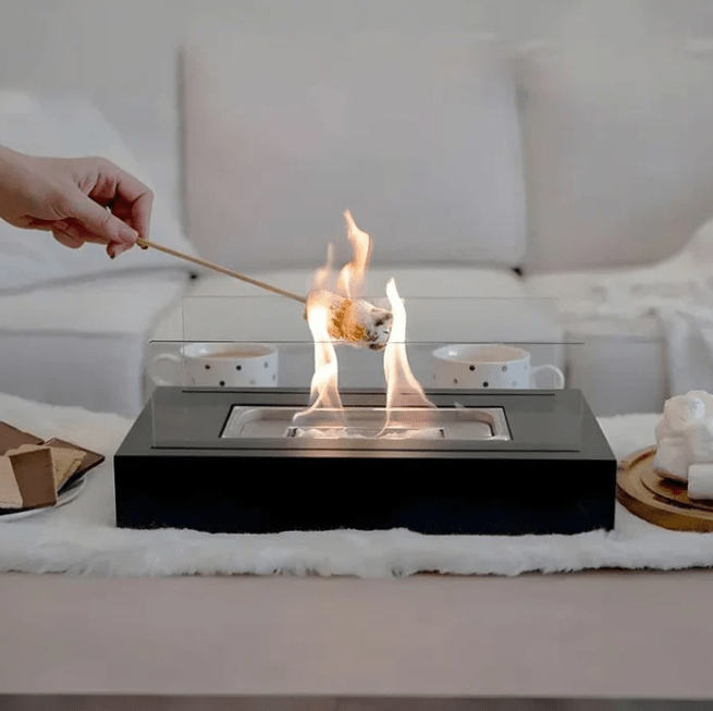 "Modern portable rectangular tabletop fire pit with real flame, sleek black design, tempered glass, and stainless steel body.