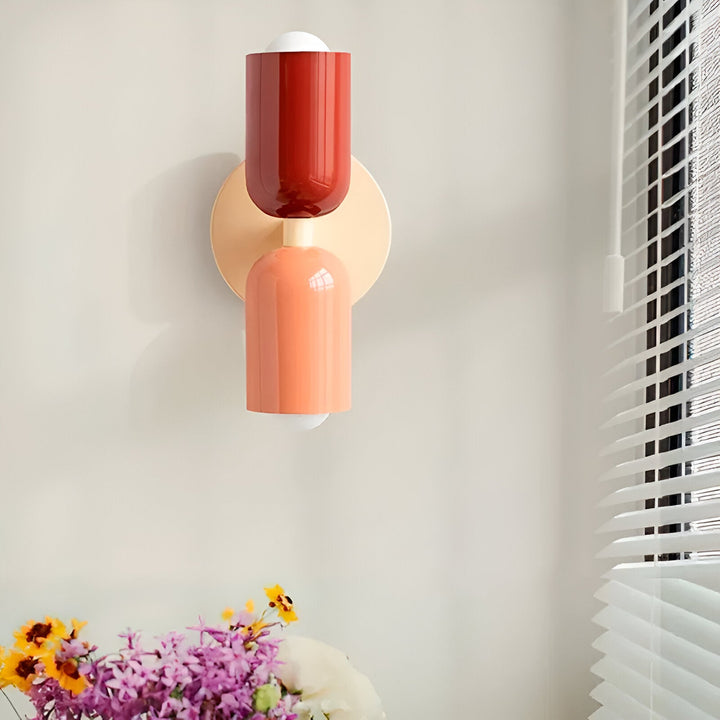 Nordic colourful double head wall light in vibrant colors, painted iron, sleek cylindrical design, casts light up and down.