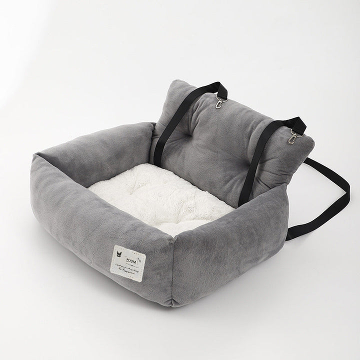 "Soft cushioned dog car seat with safety straps for secure travel, fitting most vehicles, ideal for comfortable pet journeys.