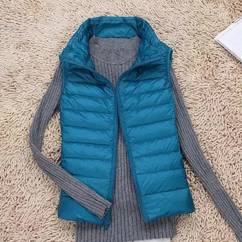 "Ultra-light women's autumn down vest in sleek fit, available in Black, Blue, Khaki; stylish and packable for cool days."
