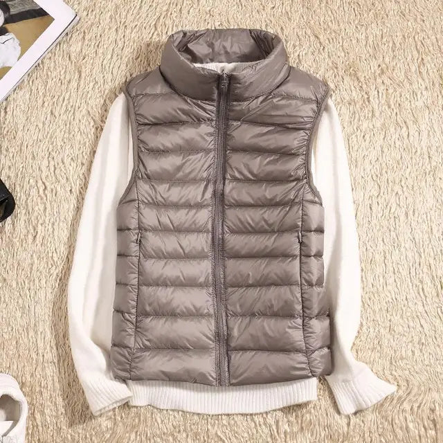 "Ultra-light women's autumn down vest in sleek fit, available in Black, Blue, Khaki; stylish and packable for cool days."