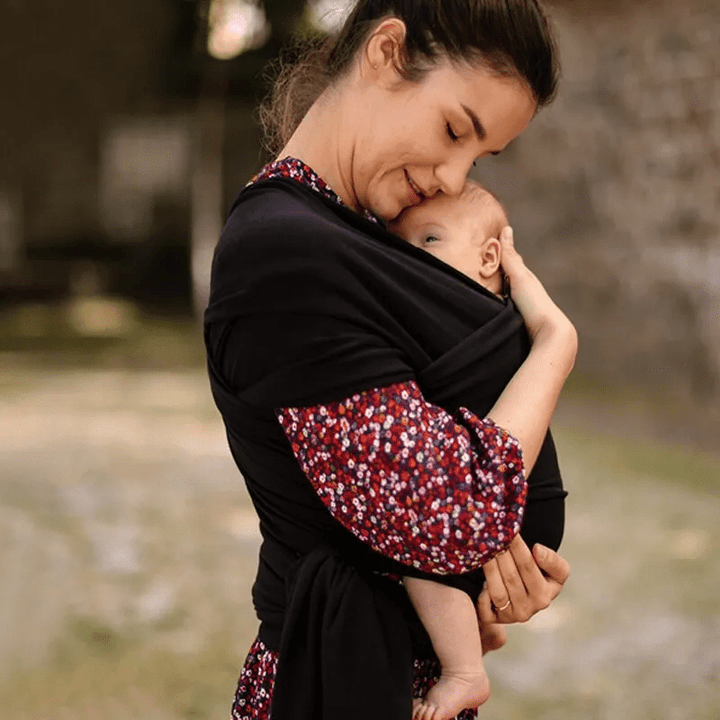 "Unisex ergonomic baby wrap carrier, grey, enveloping baby and parent comfortably for hands-free convenience."