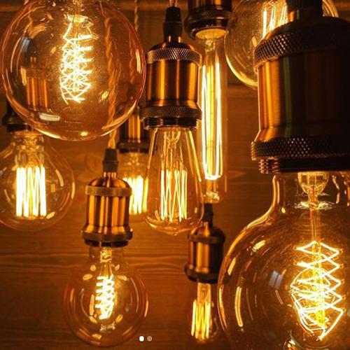 Vintage-style amber light bulbs emitting warm glow, suitable for cozy settings, with filament detail and dimmable feature.