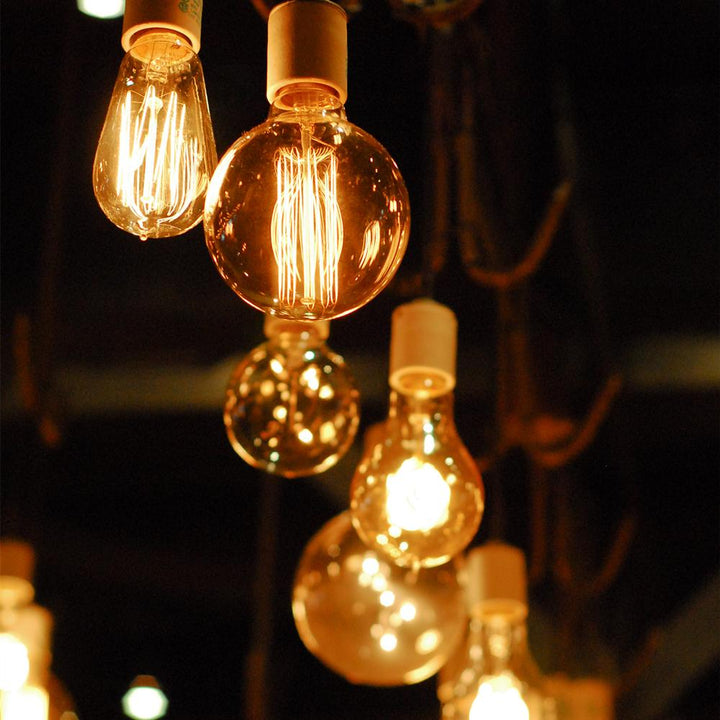 Vintage-style amber light bulbs emitting warm glow, suitable for cozy settings, with filament detail and dimmable feature.