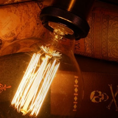 Vintage-style amber light bulbs emitting warm glow, suitable for cozy settings, with filament detail and dimmable feature.