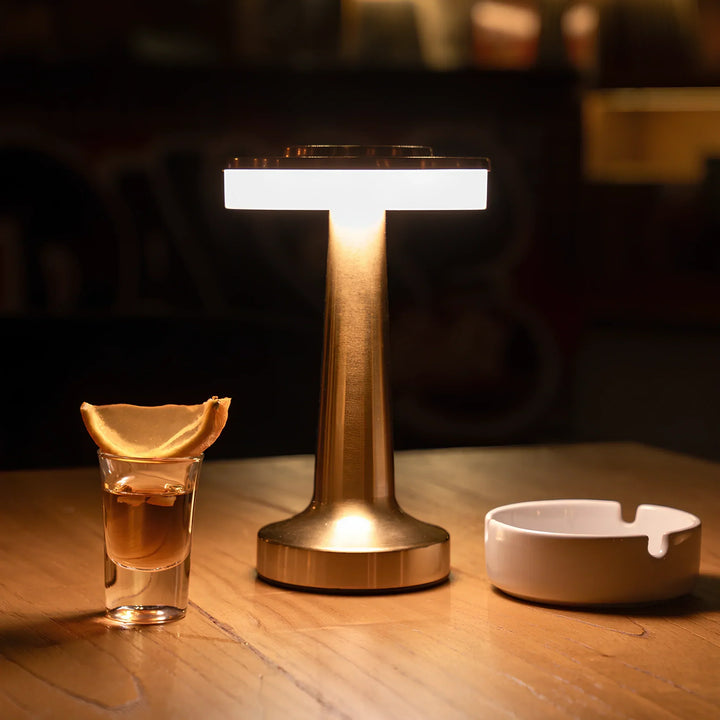 "Wireless retro table lamp with luxurious metallic finish, dimmable LED light, versatile cordless design for any setting."