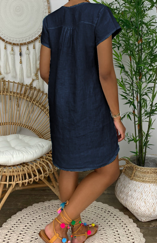 "Women's V-neck linen dress with curved hem and rolled sleeves, shown from the front in light, breathable fabric."