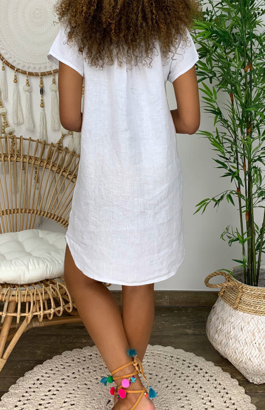 "Women's V-neck linen dress with curved hem and rolled sleeves, shown from the front in light, breathable fabric."