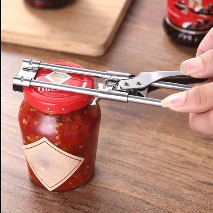 Ergonomic kitchen adjustable jar opener made of stainless steel, demonstrating use on a glass jar lid.