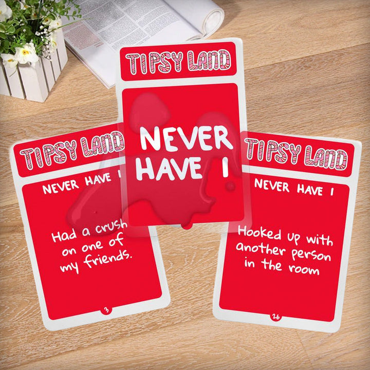 Friends cheering and holding cards from the Adult Party Drinking Game, celebrating good times.