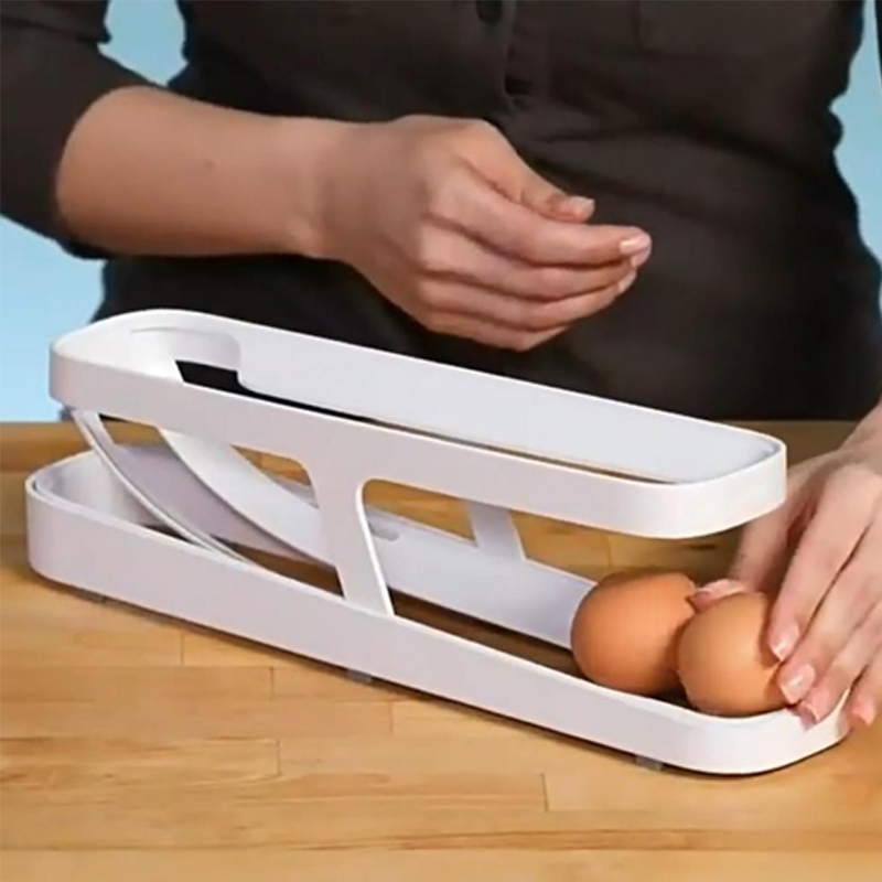 Hands placing eggs into the top of the Automatic Rolling Egg Dispenser, showing easy refilling.
