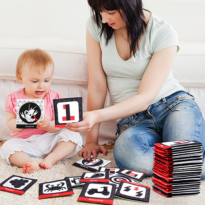 Baby playing with an interactive soft cloth book, exploring textures and shapes