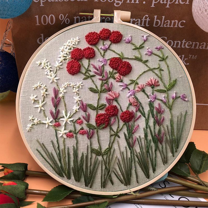 Close-up of a hand embroidering a flower design from the beginner's DIY kit.