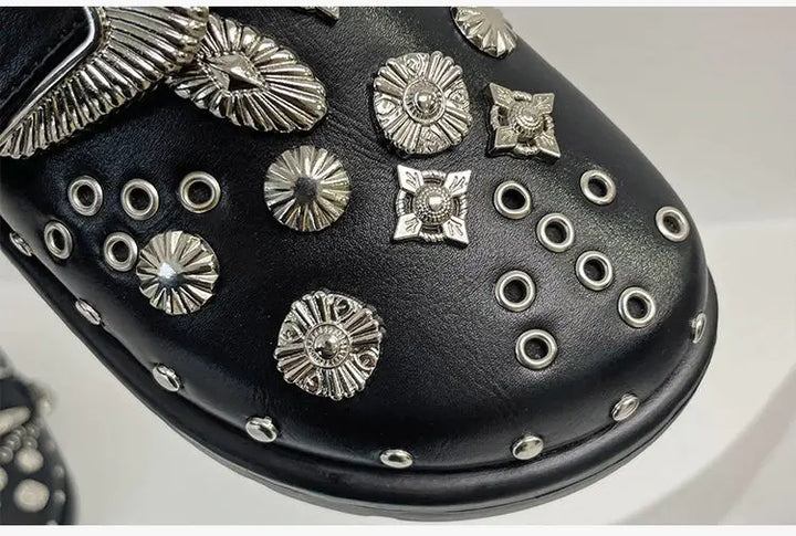 Close-up of the studded straps on women's edgy black platform sandals, showcasing detail.