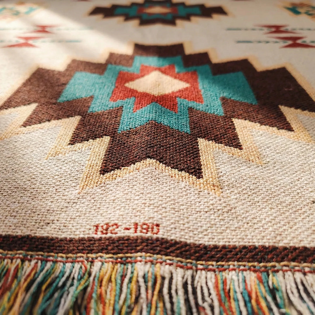 Textured Flowique boho geometric throw blanket with fringe. Woven southwestern home decor accent for any room.