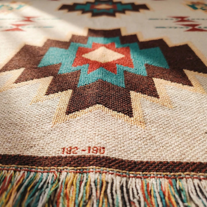 Textured Flowique boho geometric throw blanket with fringe. Woven southwestern home decor accent for any room.