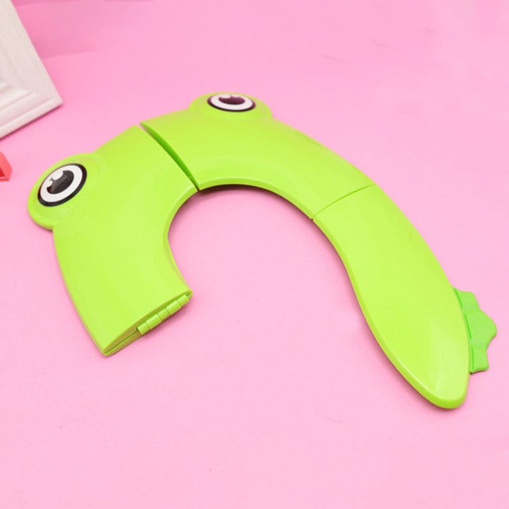Green children's portable potty seat, folded view, highlighting its lightweight and compact design