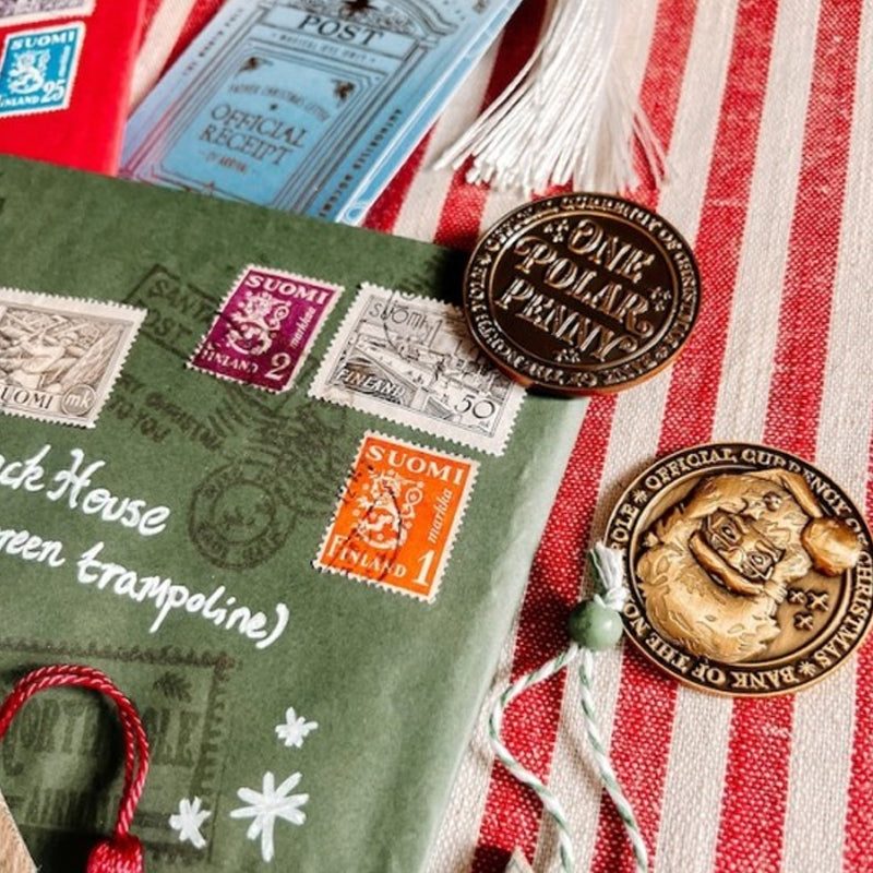 Close-up of North Pole themed Polar Pennies and their velvet pouch, a charming holiday collectible