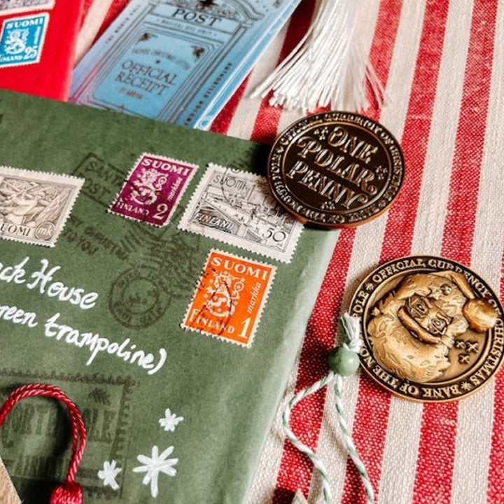 Close-up of North Pole themed Polar Pennies and their velvet pouch, a charming holiday collectible