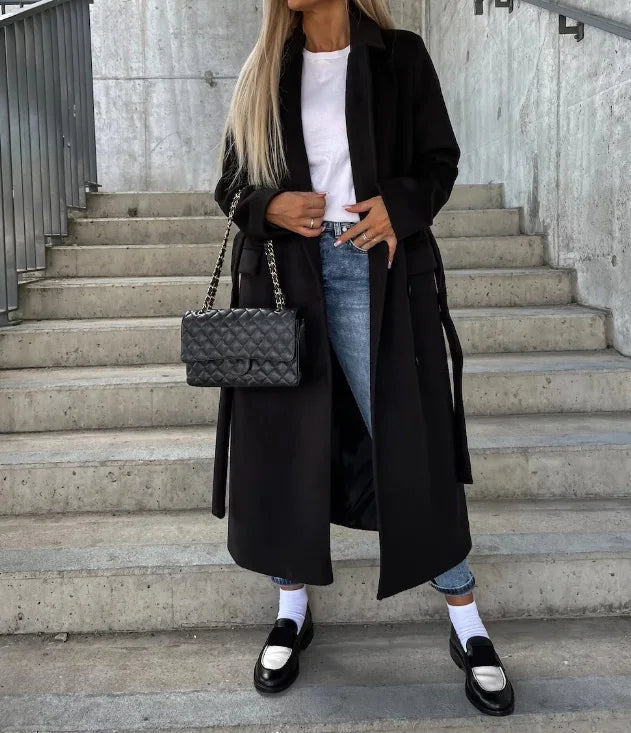 Women's classic long sleeve trench coat with belt detail, suitable for sophisticated fall fashion.