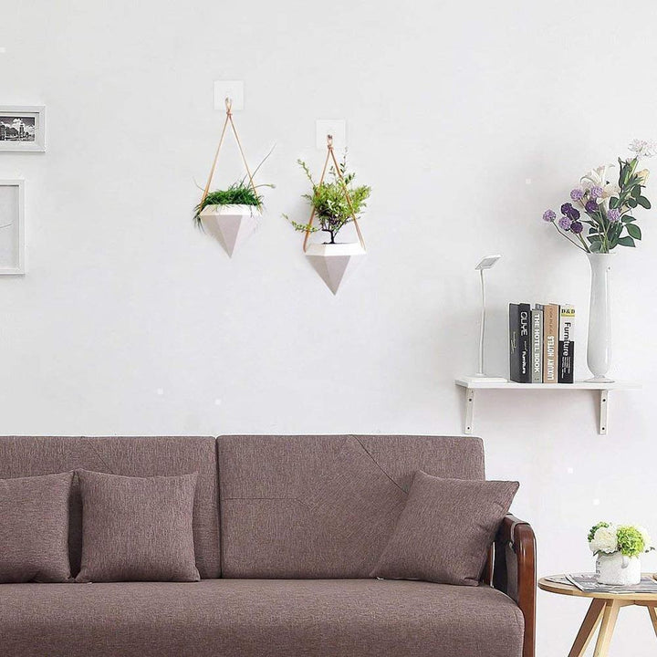 Two clear sticky hooks holding a framed picture without drilling, transparent home decor hanger