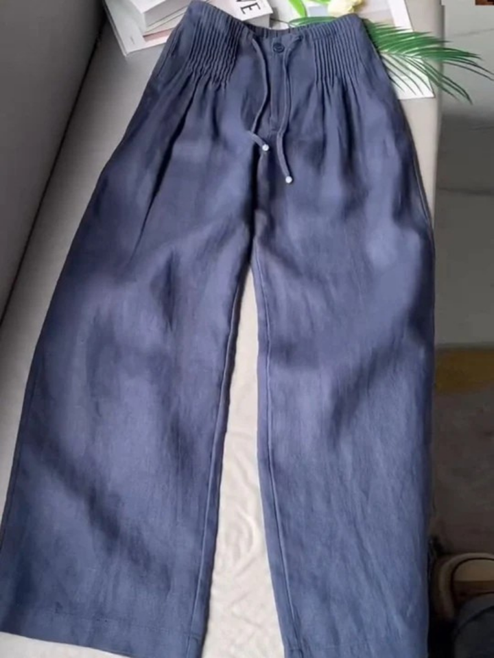 Close-up of women's flowy wide-leg trousers, showing elastic waist & fabric texture for comfort.